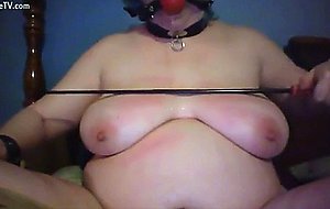 Woman uses riding crop on own tits