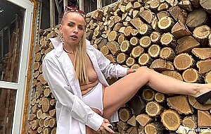 Hot blonde masturbating by some cut logs